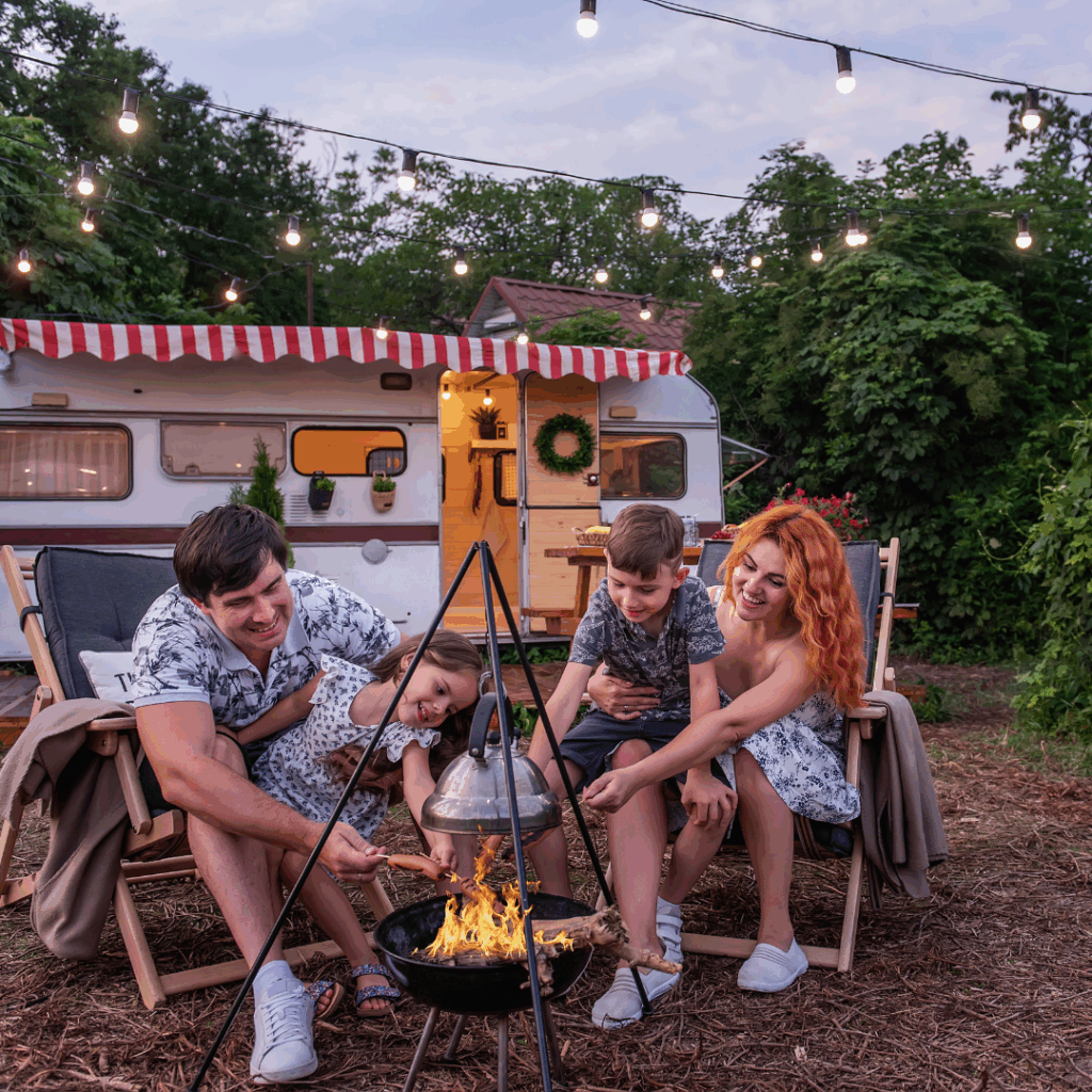Family of four in front of a RV and campfire setup. It looks like they are living in a RV Full Time!