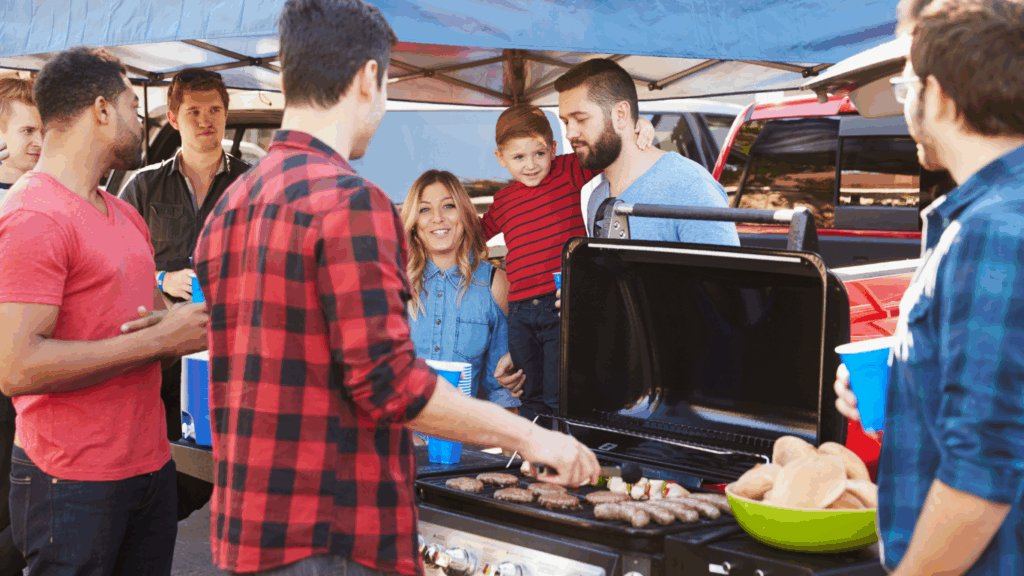 RV tailgate group standing in front of a grill and cooking