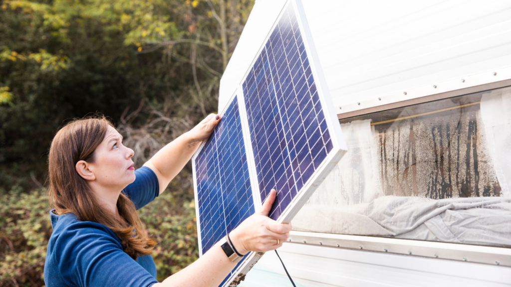 Woman placing a solar panel on a RV door